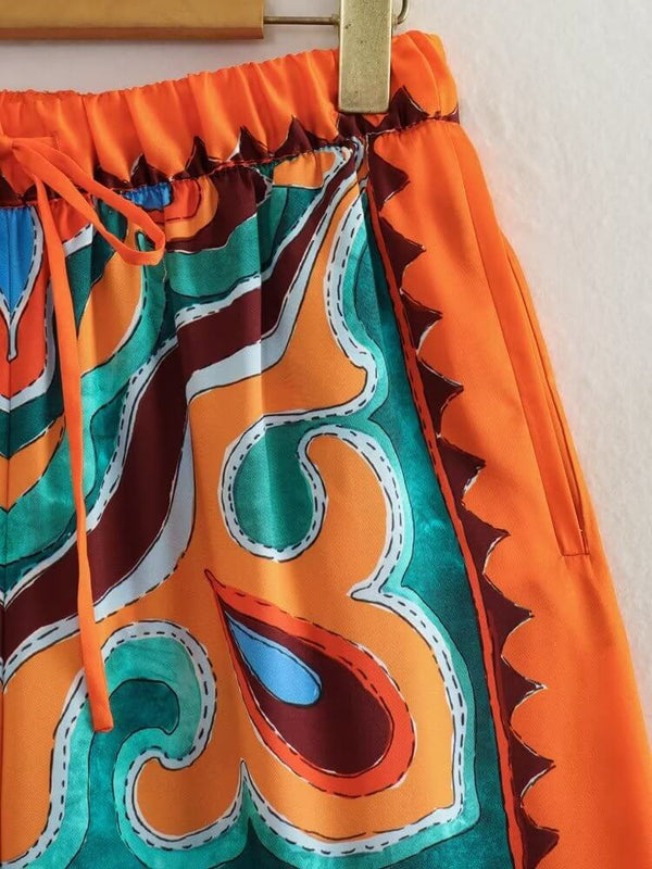 Pantalon en satin orange aux motifs colorés